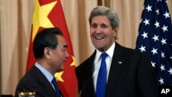 Secretary of State John Kerry talks with with Chinese Foreign Minister Wang Yi as they wrap up their news conference at the State Department in Washington, Feb. 23, 2016. (AP Photo/Susan Walsh)
