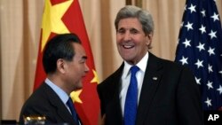 Secretary of State John Kerry talks with with Chinese Foreign Minister Wang Yi as they wrap up their news conference at the State Department in Washington, Feb. 23, 2016.