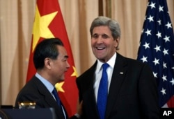 Secretary of State John Kerry talks with with Chinese Foreign Minister Wang Yi as they wrap up their news conference at the State Department in Washington, Feb. 23, 2016.