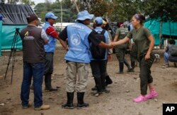 A United Nation observer shakes hands with a rebel of Revolutionary Armed Forces of Colombia (FARC) before a meeting in La Carmelita near Puerto Asis in Colombia's southwestern state of Putumayo, March 1, 2017. Thousands of leftist rebels are taking an important step in Colombia’s peace process by providing to UN observers an inventory of the weaponry they will soon surrender.