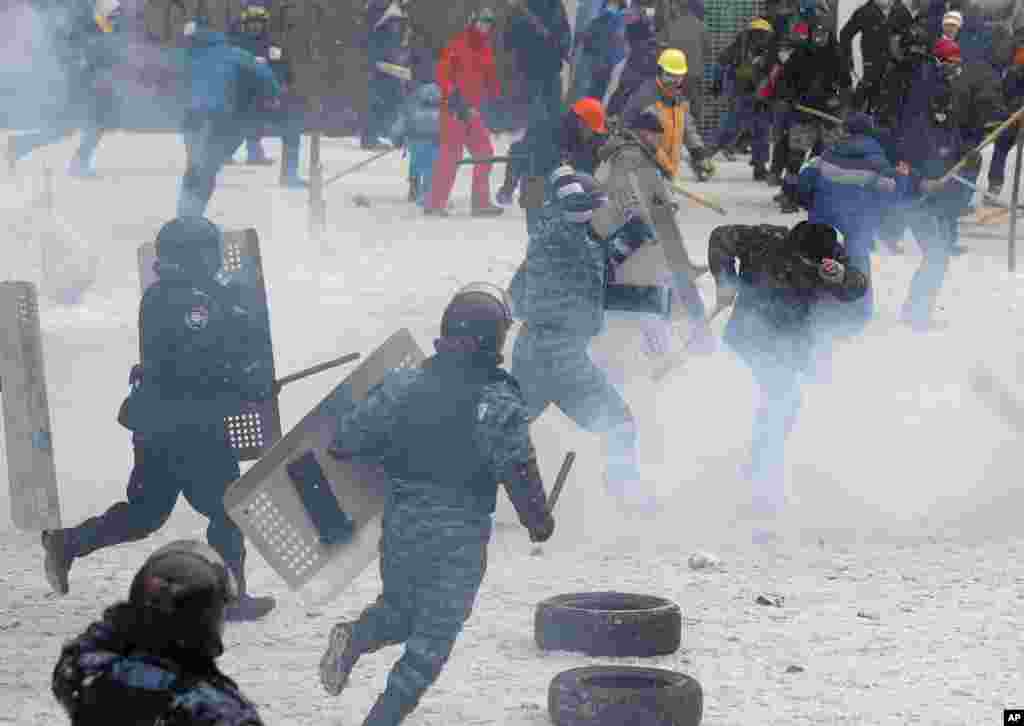 Um polícia agride um manifestante durante os confrontos no centro de Kiev, Jan. 22, 2014.