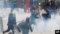 Seorang polisi anti huru-hara memukul seorang pemrotes dalam bentrokan di ibukota Kyiv (22/1).