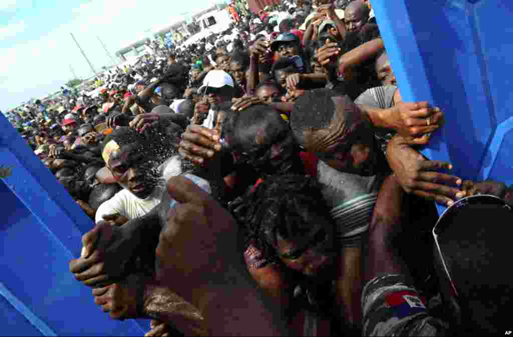 January 26: Residents of Cite Soleil in Haiti try desperately to enter the police station where an aid distribution point has been set up in Port-au-Prince. Haiti will need at least a decade of painstaking reconstruction, aid chiefs and donor nations warn