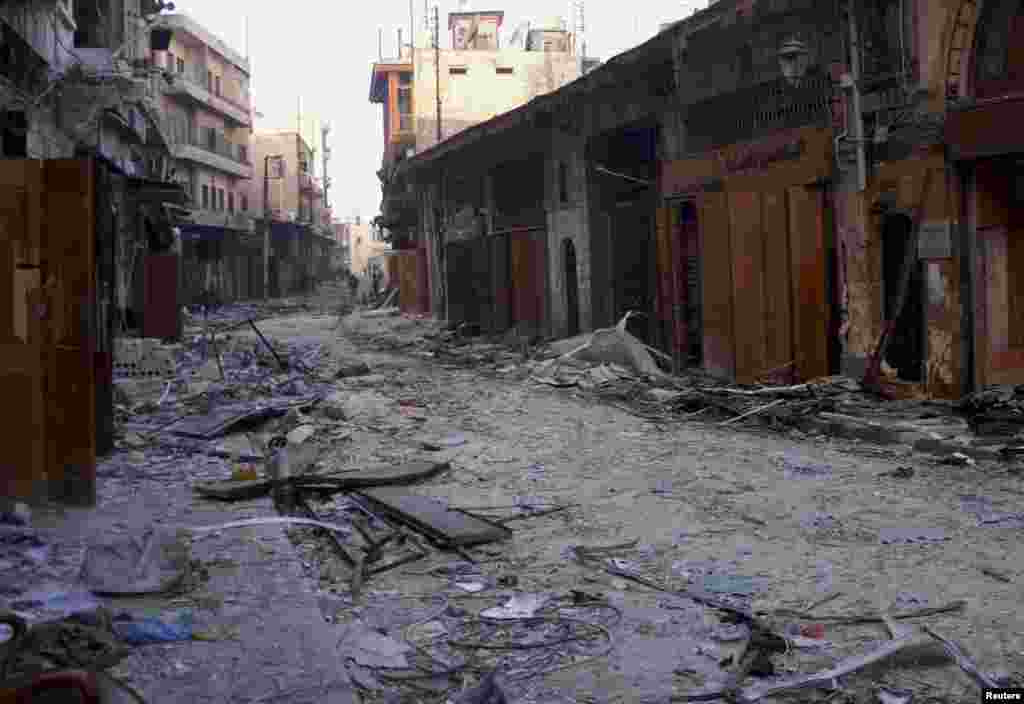 Damaged buildings and shops with members of the Syrian army patrolling in the distance in the old city of Aleppo, Syria, January 3, 2013.