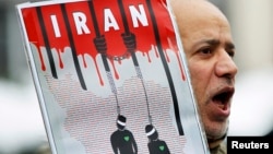 FILE - An Iranian exile shouts slogans to protest against executions in Iran during a demonstration in front of the Iranian embassy in Brussels on December 29, 2010.