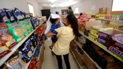 FILE - In this Aug. 23, 2019, photo, immigrants seeking asylum shop in a small store at the ICE South Texas Family Residential Center in Dilley, Texas. The isolation of at least three families at the center at that time raised fears of the coronavirus spreading through the facility.
