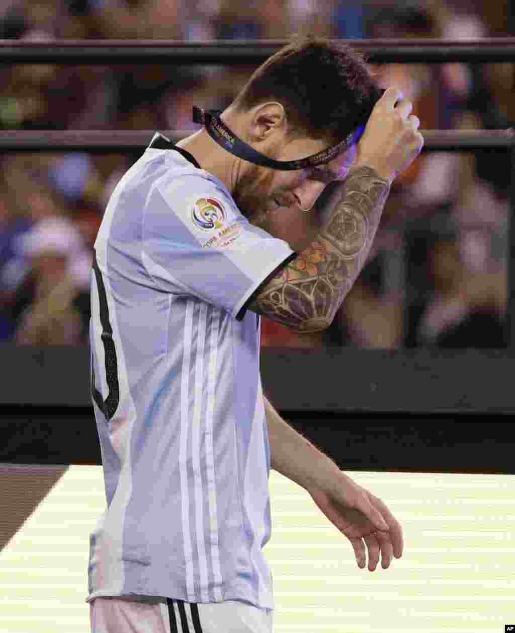O craque argentino, Lionel Messi, tira a medalha de 2&ordm; lugar, após perder com o Chile