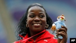 FILE - Cuba's Yarelys Barrios poses with her bronze medal for the women's discus throw during the medals ceremony at the World Athletics Championships in the Luzhniki stadium in Moscow, Russia, Aug. 12, 2013. She was stripped of the silver medal in the women's discus from the 2008 Beijing Olympics on Thursday after testing positive in a reanalysis of her doping samples.