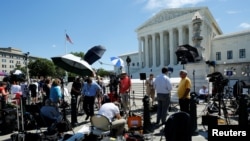 미국 연방 대법원이 26일 도널드 트럼프 대통령의 이민 관련 행정명령의 일부 효력을 인정한다고 판결했다. 이 날 미국 워싱턴의 대법원 건물 앞에 기자들이 대기하고 있다.