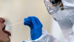 In this Wednesday, April 1, 2020 filer, medical staff of a mobile unit take samples from a woman to test for Covid-19, at the Santa Maria della Pieta' hospital complex, in Rome. (Cecilia Fabiano/LaPresse via AP, File)