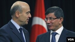 Menlu Turki Ahmet Davutoglu (kanan) menerima kunjungan Menlu Perancis Alain Juppe di Ankara (18/11).