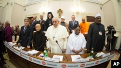 In this photo provided by Vatican newspaper L'Osservatore Romano, Pope Francis, center, and from left, Rabbi Abraham Skorka, Venerable Bhikkhuni Thich Nu Chan Khong, Her Holiness Mata Amritanandamayi and Undersecretary of State of Al Azhar Alsharif, Abbas Abdalla Abbas Soliman, pose after the signing a joint Declaration of Religious Leaders against Modern Slavery, at the Vatican, Dec. 2, 2014.