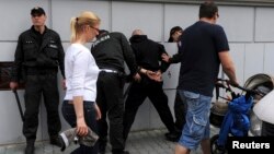 FILE - Policemen detain a member of a Slovak far-right radical organization during a rally in Bratislava, Slovakia, May 22, 2010.