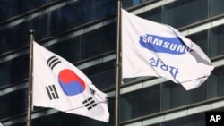 在韩国首尔，三星电子公司的旗帜在韩国国旗旁边飘动。（ 2017年1月16日）