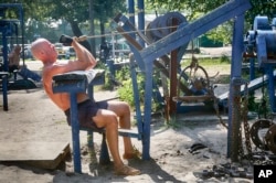 A man lifts weights at an outdoor gym in a city park in Kiev, Ukraine. (AP Photo)