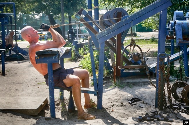 A man lifts weights at an outdoor gym in a city park in Kiev, Ukraine. (AP Photo)