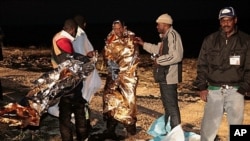 Migrants receive assistance as they arrive on the tiny island of Lampedusa, Italy, May 8, 2011 (file photo).