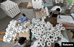 Para pekerja terlihat di lini produksi di sebuah pabrik tekstil kapas di Korla, Daerah Otonomi Uighur Xinjiang, China, 1 April 2021. (Foto: via Reuters)