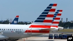 FILE - American Airlines planes wait on the tarmac at Washington's Reagan National Airport.