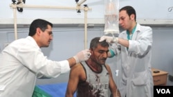 Syrian doctors treat an injured man who was wounded after two bombs exploded, at Qazaz neighborhood in Damascus, Syria, May 10, 2012.