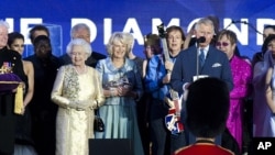 Britain's Prince Charles and Queen Elizabeth II are joined on stage with the rest of the Royal family as well as performers at the Queen's Jubilee Concert in front of Buckingham Palace, London, June 4, 2012. 
