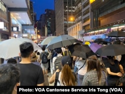 参与中环流水式游行人士占据马路，高举雨伞，导致交通受阻，但是没有捣路及冲击警方，游行过程大致和平 (美国之音/汤惠芸）