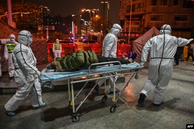 2020年1月25日穿着防护服的医务人员带着病人到达武汉红十字会医院。