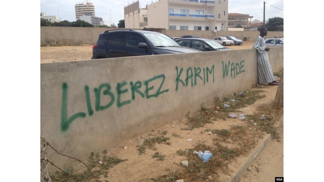 A spray-painted message reads "Free Karim" and is a common sight Sengalese capital as the corruption trial of Karim Wade continues, Nov. 11, 2014. (Christin Roby/VOA)