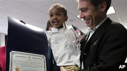 Aaron Lieberman holds his son Theodore, 2, adopted from Ethiopia, as he shows his citizenship certificate, during U.S. Citizenship and Immigration Services (USCIS) Adoption Day ceremony in New York, 18 Nov 2010