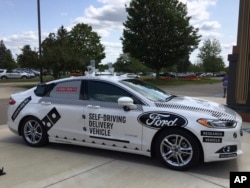 FILE - An Aug. 24, 2017, photo, shows the specially designed delivery car that Ford Motor Co. and Domino’s Pizza will use to test self-driving pizza deliveries, at Domino’s headquarters in Ann Arbor, Michigan.