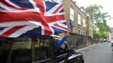 A taxi driver holds a Union flag, as he celebrates following the result of the EU referendum, in central London, Britain.