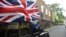 A taxi driver holds a Union flag, as he celebrates following the result of the EU referendum, in central London, Britain.