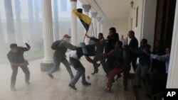 Законодатели-оппозиционеры участвуют в потасовке проправительственными активистами, когда те пытаются прорваться вздание парламента страны. Каракас. Венесуэла. 5 июля 2017 г.