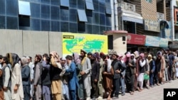 Afghans wait in front of Kabul Bank, in Kabul, Afghanistan, Aug. 25. 2021. 