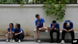 资料照片: 2023年8月3日北京街头玩智能手机的年轻人