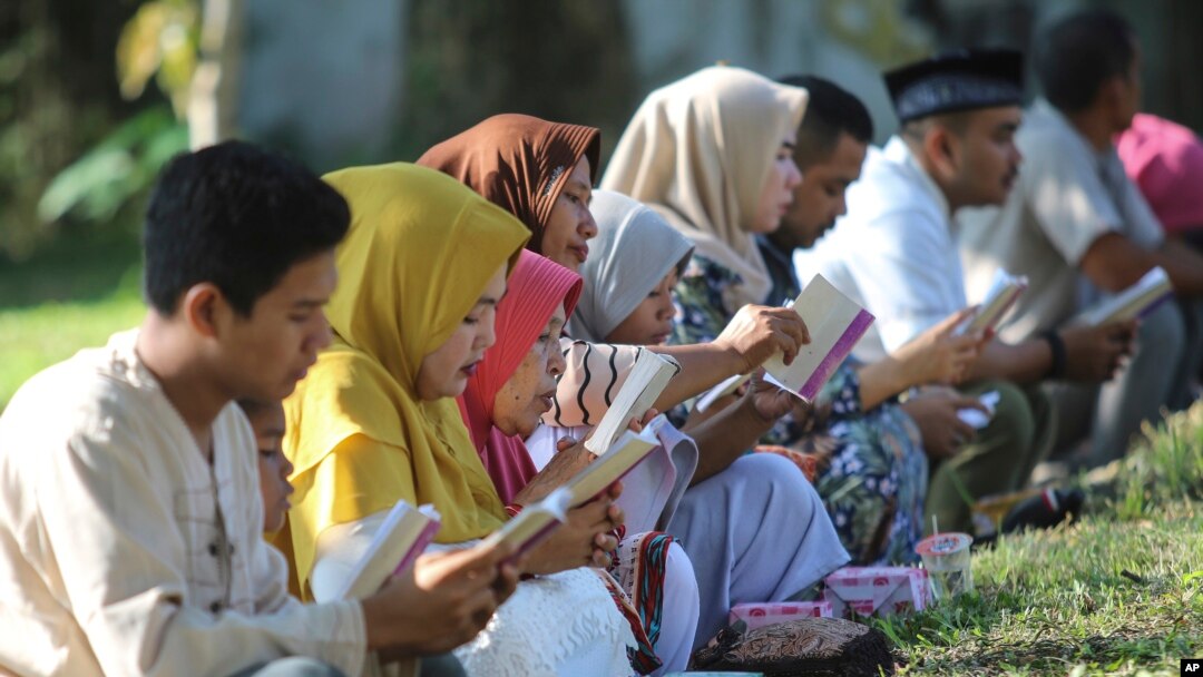 Warga membacakan ayat-ayat suci Al-Qur'an saat berziarah di kuburan massal para korban tsunami dalam peringatan 15 tahun bencana tersebut di Banda Aceh, 26 Desember 2019. 