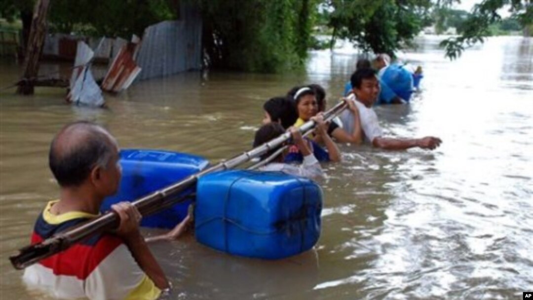 Residents wade through flood water by holding a float-attached pole as they evacuate their homes in Nakhon Ratchasima province, northeastern Thailand, 17 Oct 2010
