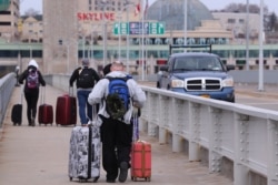 FILE - Travelers cross the Rainbow Bridge into Canada, March 18, 2020, in Niagara Falls N.Y. Canadian Prime Minister Justin Trudeau said April 18 that the U.S.-Canada border would be closed to nonessential travel for another month.