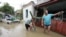 Local residents stand in a flooded courtyard of a house in the town of Krymsk, which has been seriously damaged by floods, in the Krasnodar region, southern Russia, July 8, 2012.