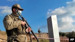 Turkish police officers guard the monolith, found on an open field near Sanliurfa, southeastern Turkey, Feb. 7, 2021, that has now disappeared.