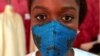 La créatrice de mode Sophie Zinga pose avec un masque facial, qu'elle a conçu comme mesure de protection pour endiguer la propagation du coronavirus, dans son atelier à Dakar, au Sénégal, le 14 mai 2020. 