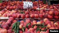 Peaches are displayed on a fruit vendor's stall at a grocery market in Athens, Greece, Aug. 8, 2014. 