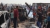 Palestinos se reúnen en el lugar de un ataque israelí contra un campamento de desplazados internos en Rafah el 27 de mayo de 2024.
