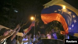 Para pendukung oposisi koalisi Partai Persatuan Demokratik Venezuela merayakan kemenangan mereka dengan melambaikan bendera Venezuela di jalanan kota Caracas (7/12).