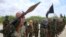 FILE - Al-Shabab fighters display weapons as they conduct military exercises in northern Mogadishu, Somalia, Oct. 21, 2010.