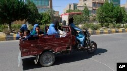 Sejumlah perempuan dan anak-anak Afghanistan naik kendaraan bermotor saat pertemuan antara Taliban dan pasukan keamanan Afghan di Provinsi Herat, bagian barat Kabul, Afghanistan, 1 Agustus 2021. (Foto: Hamed Sarfarazi/AP)