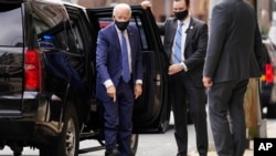 El presidente electo Joe Biden señala su bota ortopédica al llegar al Teatro Queen en Wilmington, desde donde realizó una reunión virtual con trabajadores y empresarios.