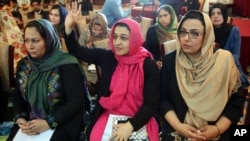 Executive Director for Afghan women’s Network (AWN), Hasina Safi, center, raises her hand to ask a question during a press conference by Amnesty International announcing their report on threats to women activists in Kabul, Afghanistan, Tuesday, April 7, 2015. (AP Photo/Massoud Hossaini)