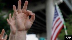 Dalam sebuah foto yang diambil pada 17 Agustus 2019 ini, tampak anggota dari kelompok sayap kanan di Amerika Serikat menunjukkan gestur tangan 'OK' yang mengacu pada supremasi kulit putih dalam sebuah demonstrasi "The End Domestic Terrorism" di Oregon. (Foto: AFP/John Rudoff)