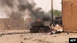 FILE - Smoke and flames ascend from an army armored vehicle in Gao, northwestern Mali, following an explosion on July 1, 2018.